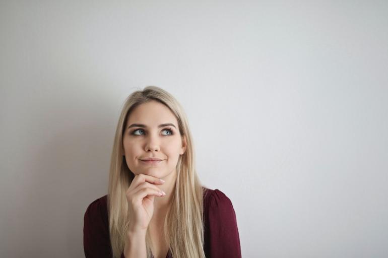 Das Ziel der WRAP-Methode ist ein möglichst offener, vielseitiger Entscheidungsprozess. (Foto: Andrea Piacquadio / Pexels.com) Eine Frau sitzt vor einer weißen Wand. Sie hat eine Hand am Kinn in nachdenklicher Stellung.